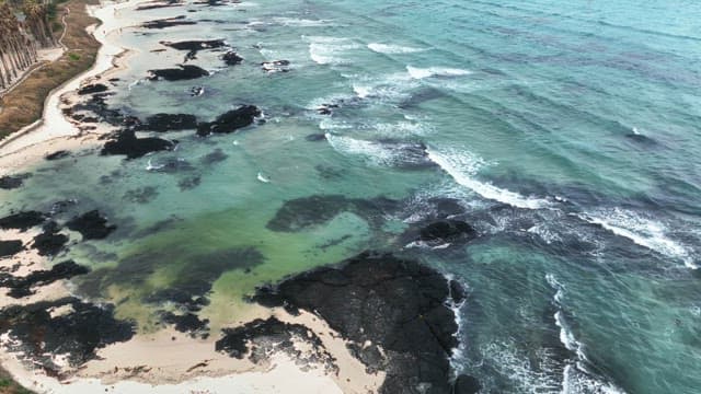 Serene beach with waves and rocks
