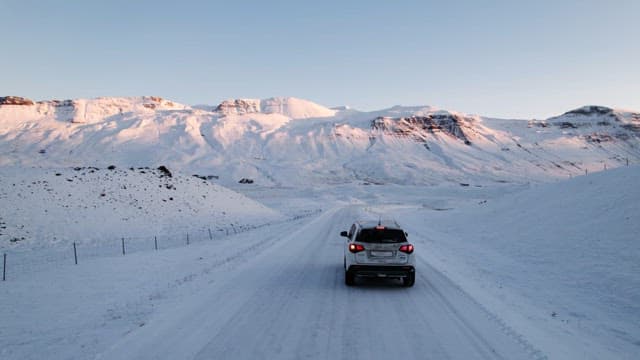 Car driving through snowy mountains