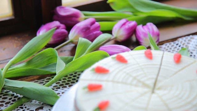 Carrot cake with purple tulips nearby