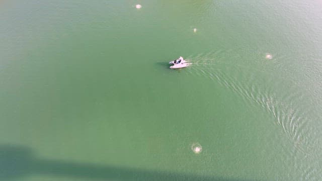 Boat Floating on a Green Lake