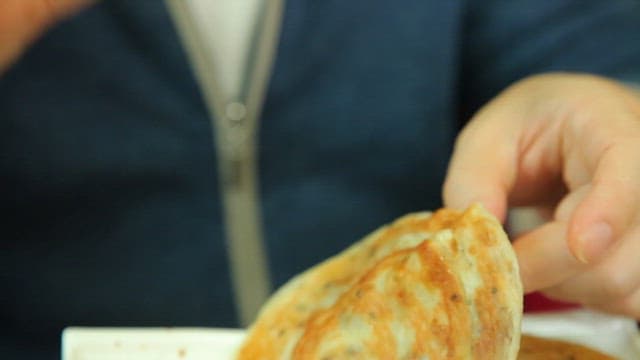 Hands holding a golden hotteok