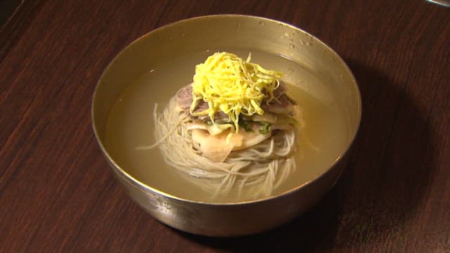 Appetizing Pyeongyang cold buckwheat noodles topped with egg custard and meat