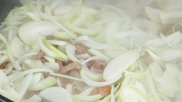 Onions and meat cooking in a pan