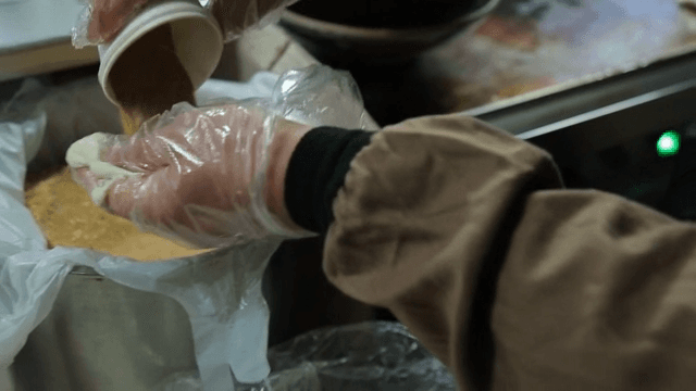Hands kneading dough in a kitchen