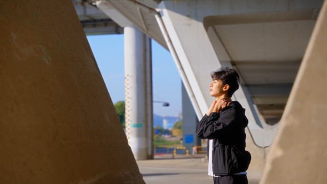 Man stretching under a bridge