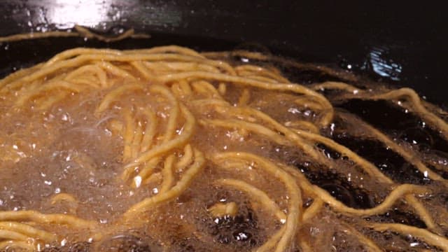 Close-up of noodles being deep-fried in oil