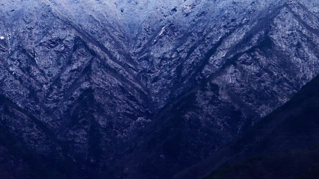Snow-covered mountains under cloudy skies