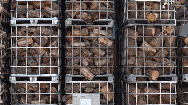 Stacked firewood in metal cages