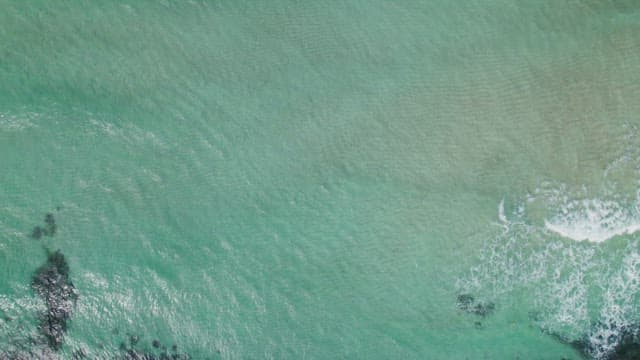 Aerial view of a turquoise sea with gentle waves