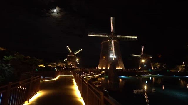 Illuminated Windmills at Night by Water