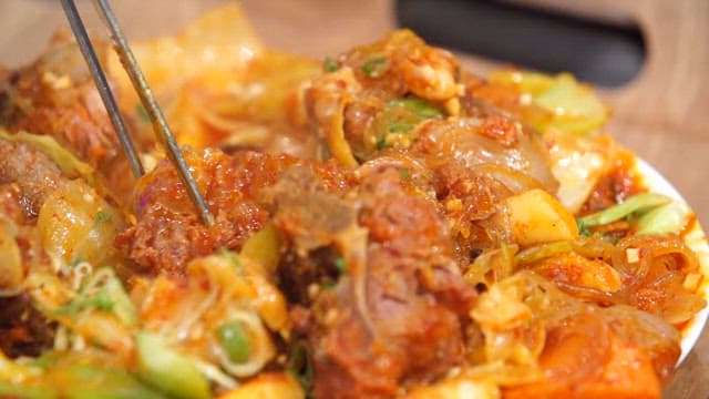 Spicy braised pork backbone meat picked up with chopsticks