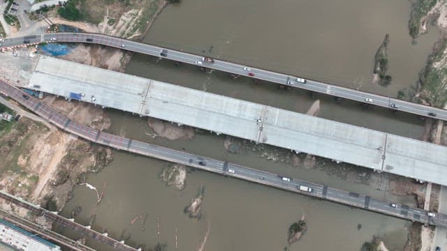 Aerial View of Traffic on Urban Bridge over River