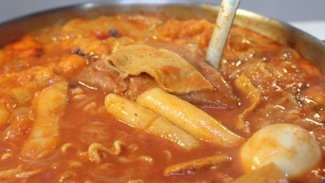 Appetizing tteokbokki with plenty of ingredients such as ramen and fish cake