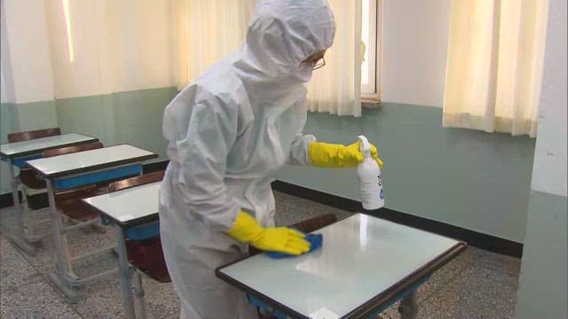 Person Sanitizing Classrooms in Protective Suit
