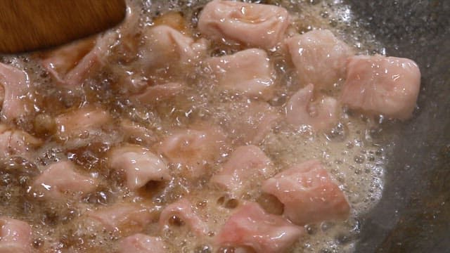 Grilled pork intestines sizzling in oil on a hot pan
