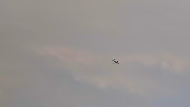 Airplane flying through colorful clouds