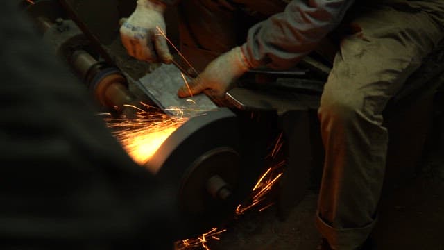 Worker sharpening a knife in a workshop