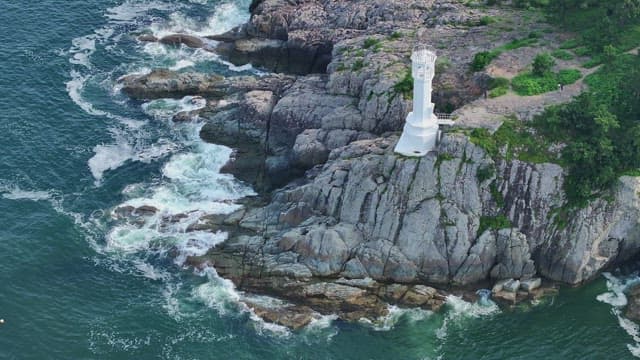 Lighthouse on rocky cliffs by the sea