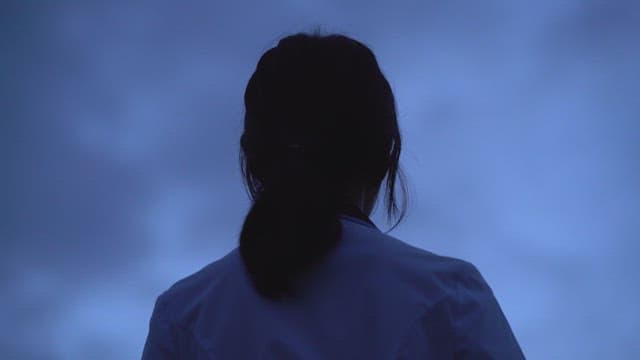 Person standing looking at the evening sky at dusk