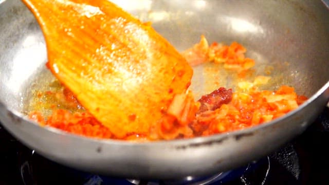 Kimchi being stir-fried in a pan