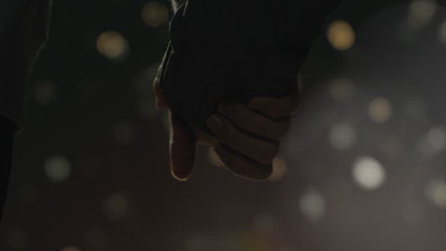 Couple holding hands in the dark night, dim lights