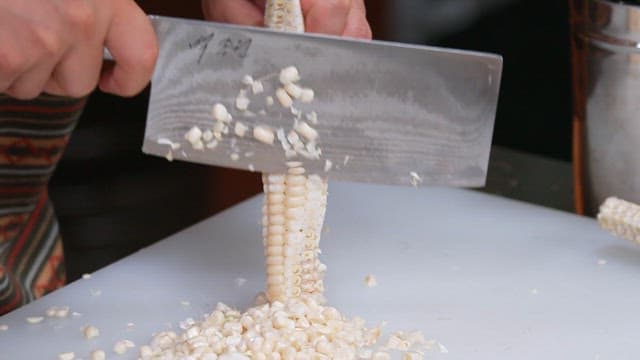Preparing Corn on a White Cutting Board in a Kitchen