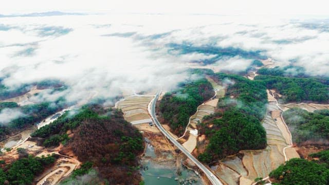 Mist-shrouded roads winding through a hilly landscape