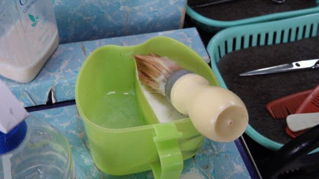 Barber getting tools prepared to shave a customer