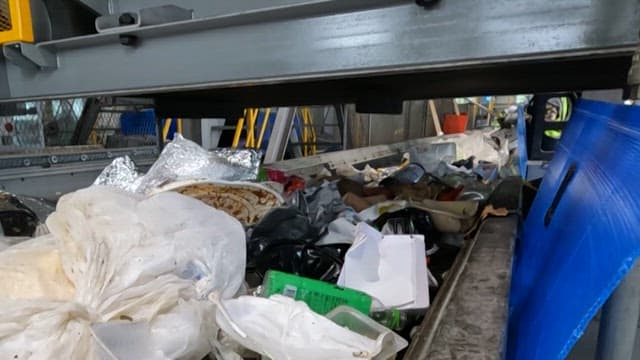 Conveyor belt transporting various waste materials indoors