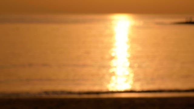 Sunset reflecting off calm ocean waters at the beach