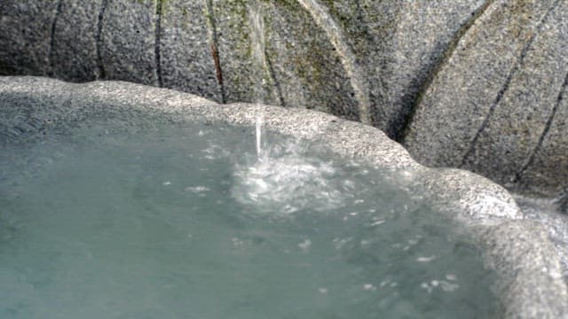 Water gently flowing into a stone basin