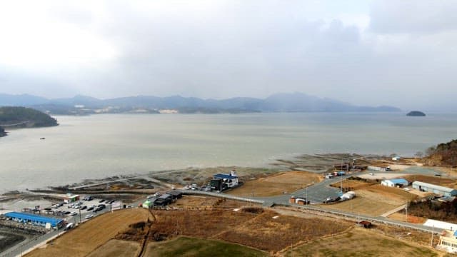 Coastal town overlooking a serene bay with mountains in the distance