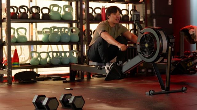 Man exercising on a rowing machine in a gym