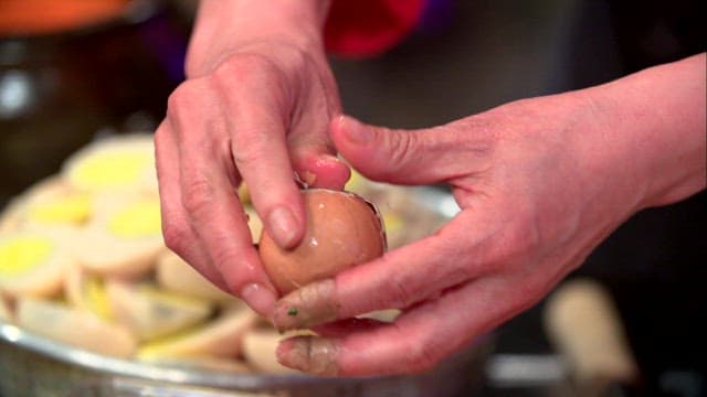 Peeling a boiled egg in the kitchen
