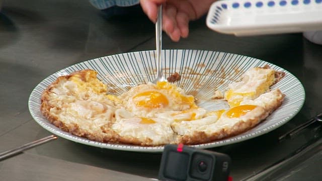 People sharing fried eggs using plates and utensils