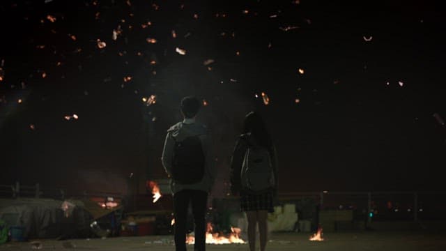 Two people standing amidst the ash from the explosion