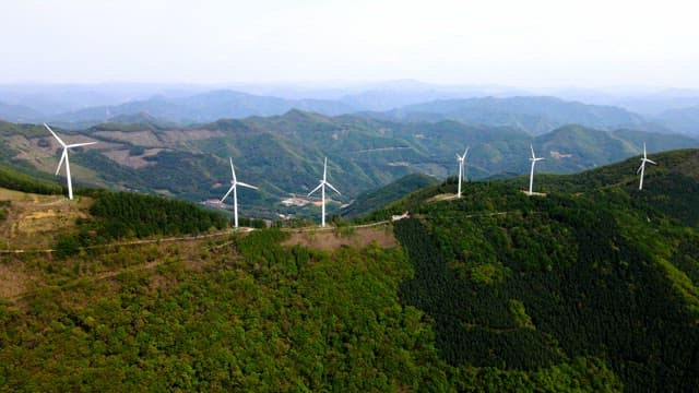 Wind turbines on a lush green mountain range