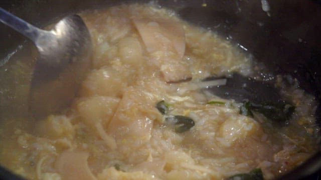 Noodle soup with chicken porridge stirred with a ladle