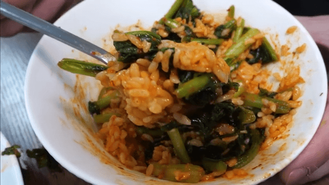 Mixing spicy young radish bibimbap in a bowl