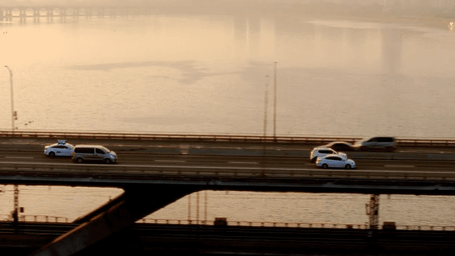 Vehicles moving on a bridge at sunset