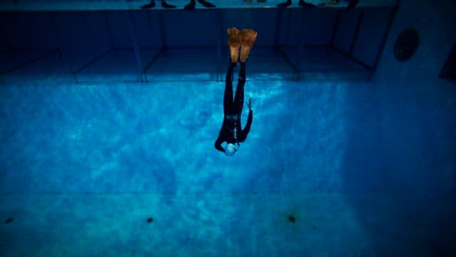 Person practicing free diving in a swimming pool