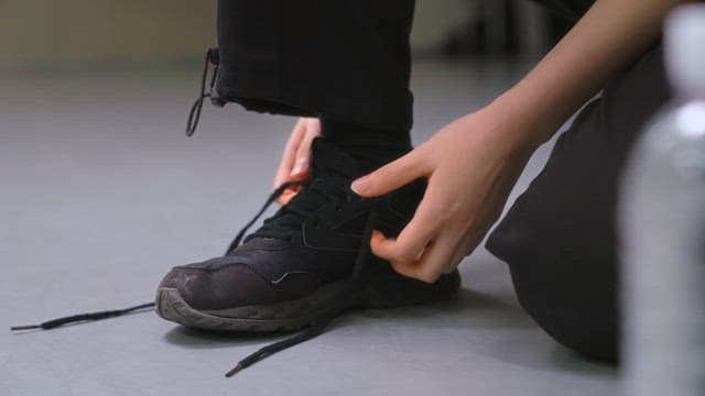 Person Tying Shoelaces Indoors
