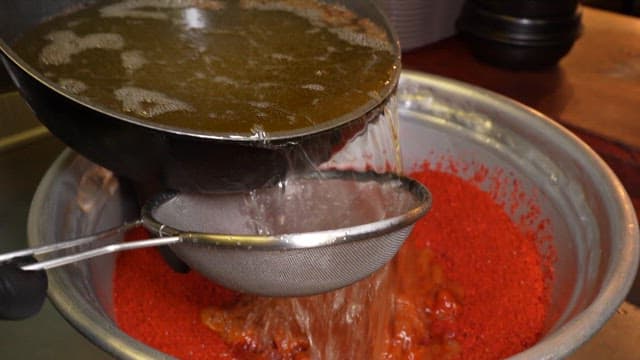 Mixing Hot Broth with Red Chili Powder