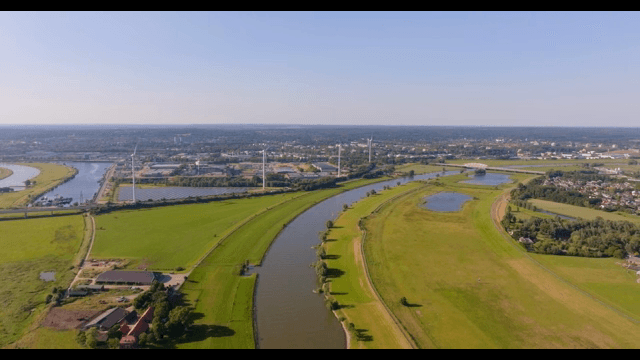 River winding through green fields and a village