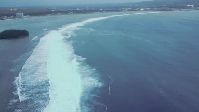 Coastal waves and distant cityscape