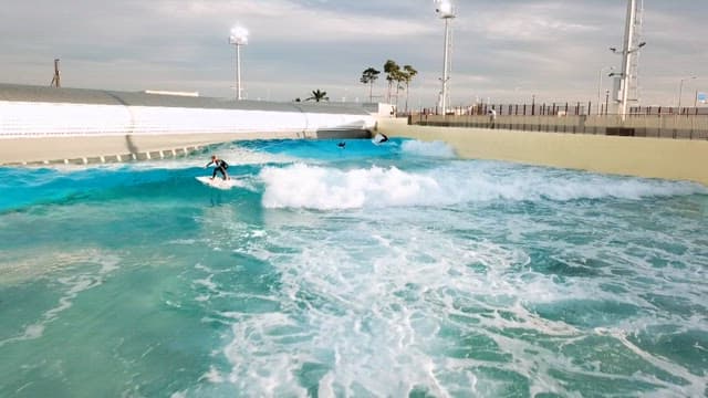 People skillfully surfing in an artificial wave pool