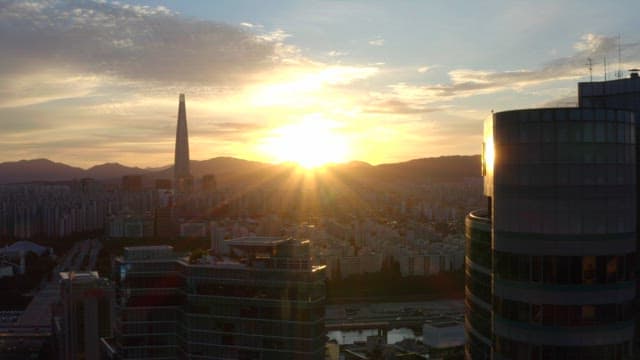 Sunset over a city skyline with mountains