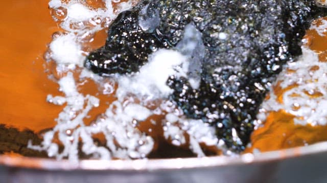 Seaweed being deep-fried in hot oil