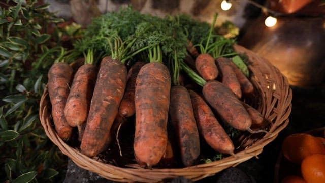 Fresh carrots and oranges in baskets