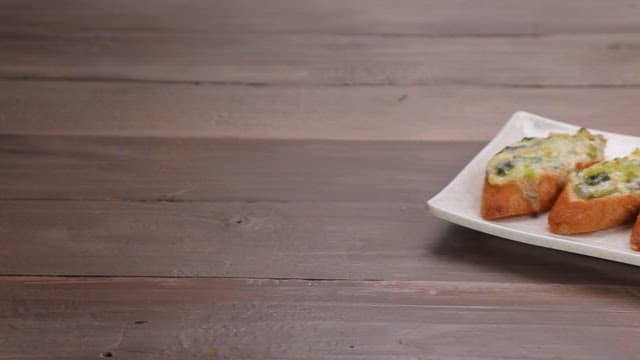 Crispy and appetizing baguette topped with green onions on a plate